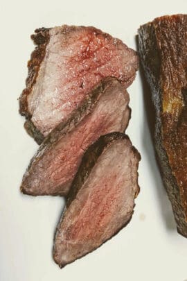 Slices of Air Fryer Roast Beef on a white plate