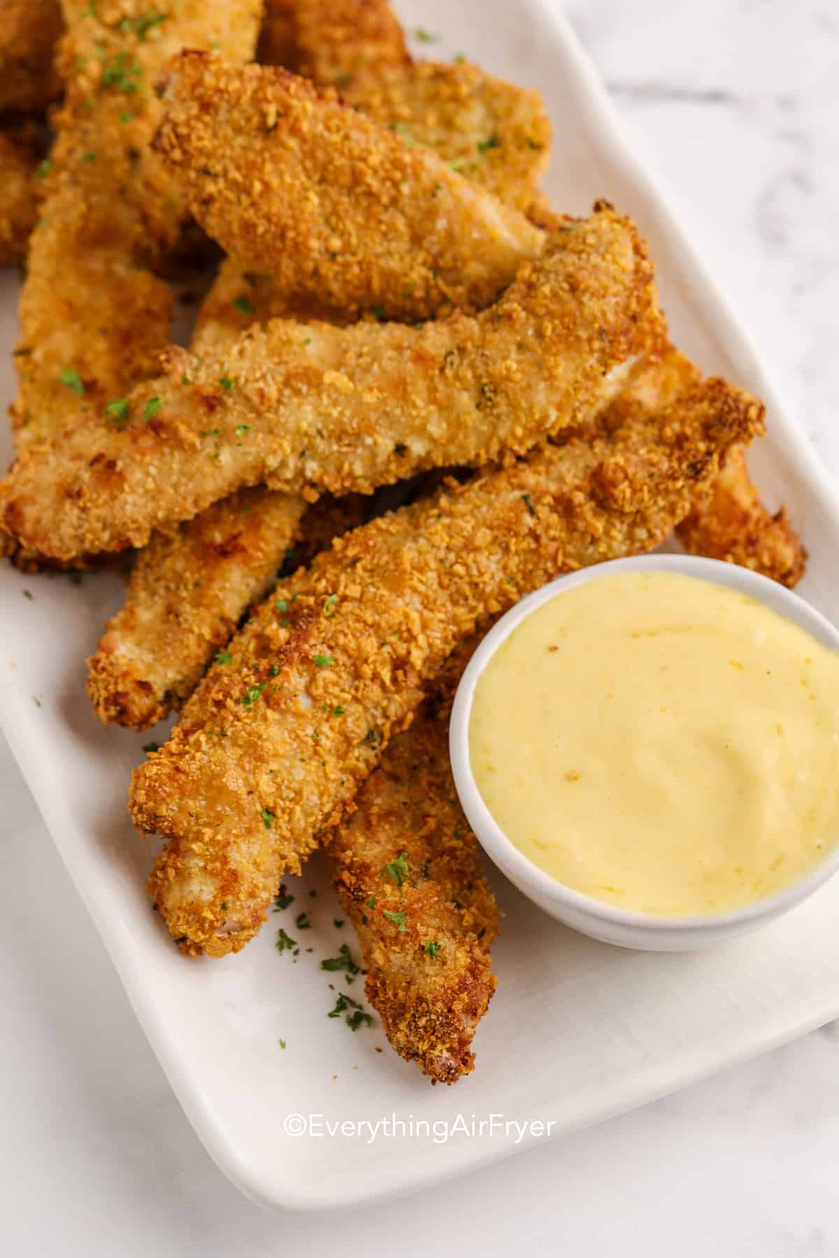 chicken tenders on a plate with mustard dip