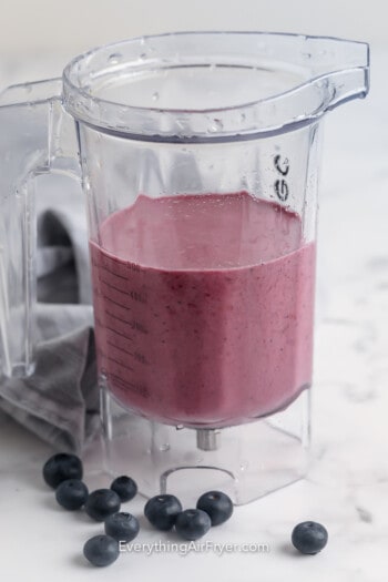 Berry smoothie ingredients blended in a blender