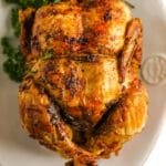 whole chicken on a plate with herbs