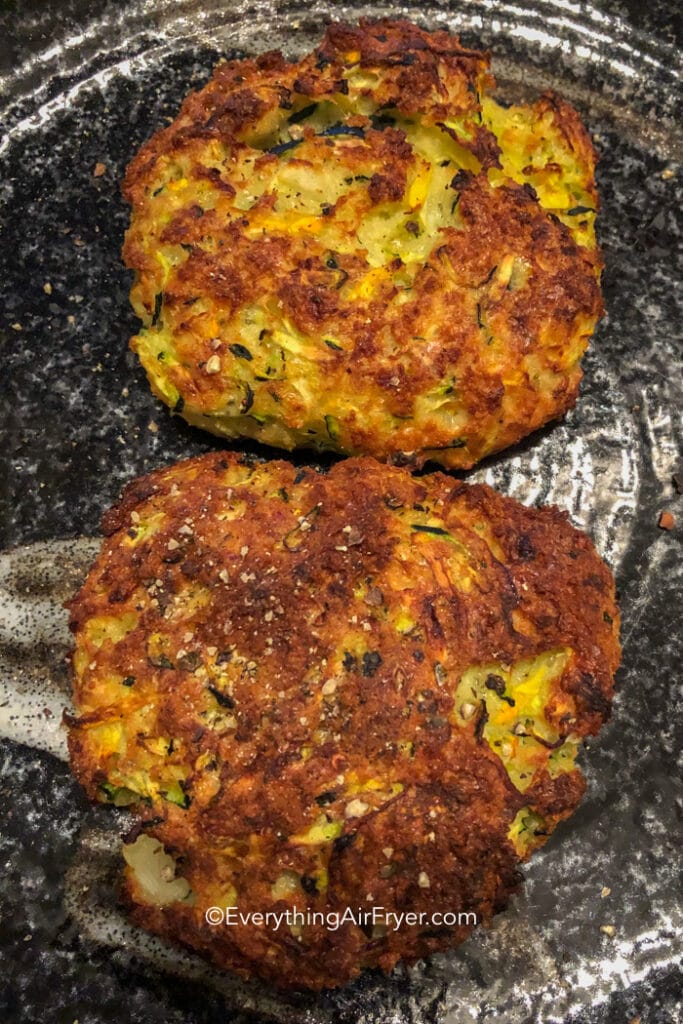 Two air fryer zucchini fritters on a plate