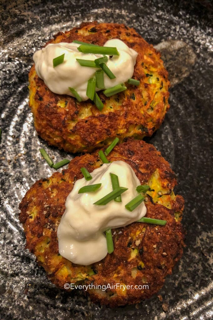 Air Fryer Zucchini Fritters topped with zour cream and green onions