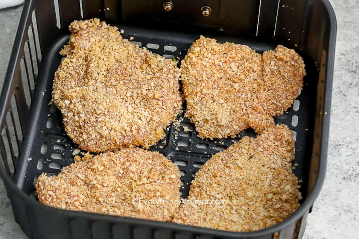 uncooked chicken cutlets in an air fryer