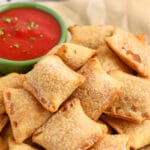 Pizza rolls in the air fryer on a plate with writing
