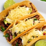 Three Air Fryer Brisket Tacos on a plate with lime wedges