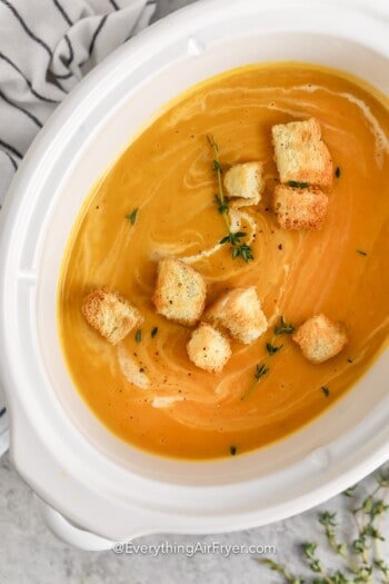 Crockpot Butternut Squash Soup garnished with croutons and thyme