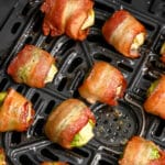 Bacon Wrapped Brussels Sprouts in an Air Fryer basket with writing