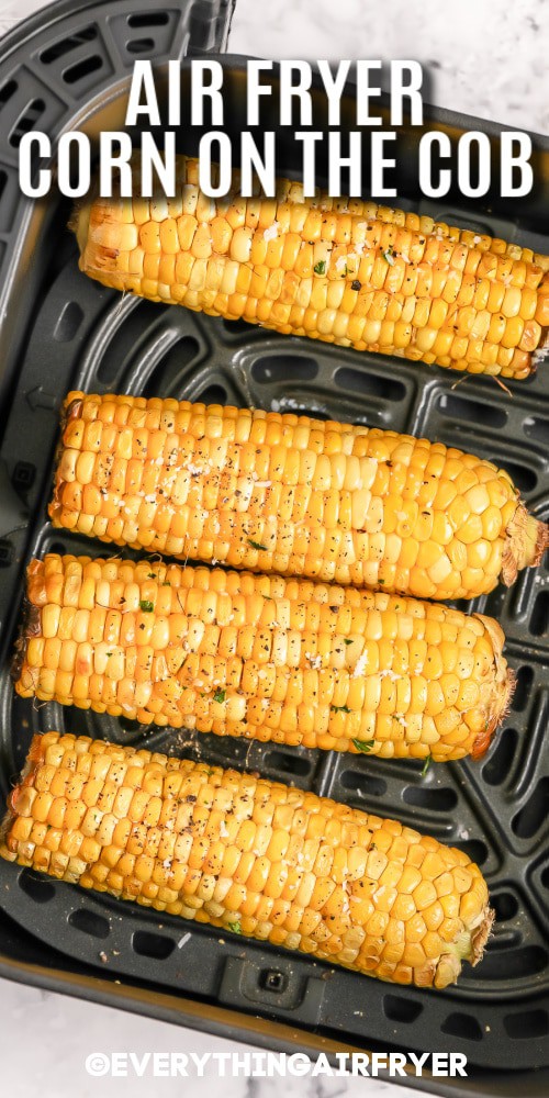 Corn on the cob in an air fryer basket with writing