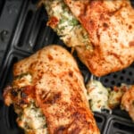 Stuffed Chicken Breasts in an air fryer basket with writing