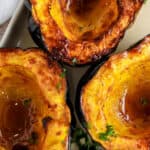 Three halves of acorn squash on a serving plate with a title