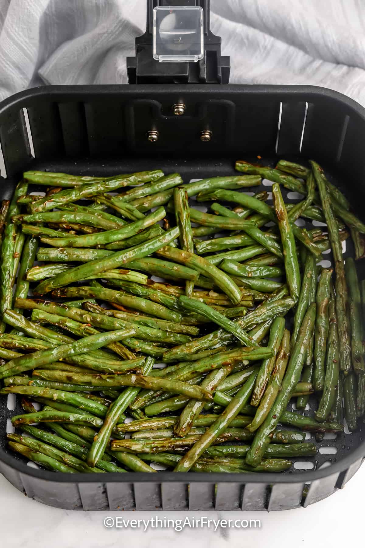 cooked green beans in an air fryer tray
