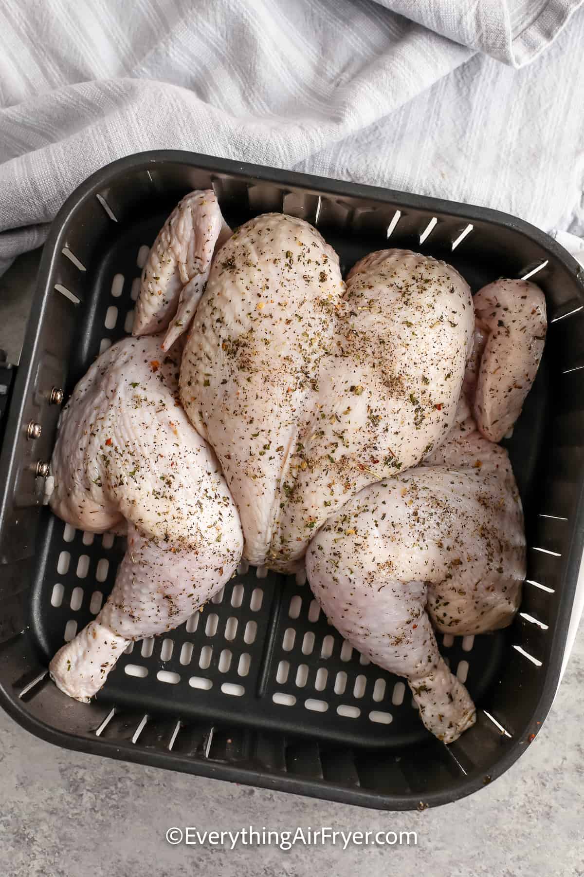uncooked whole chicken in an air fryer tray