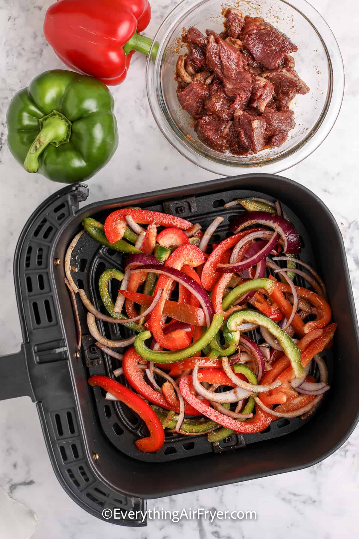 onions and peppers in an air fryer tray