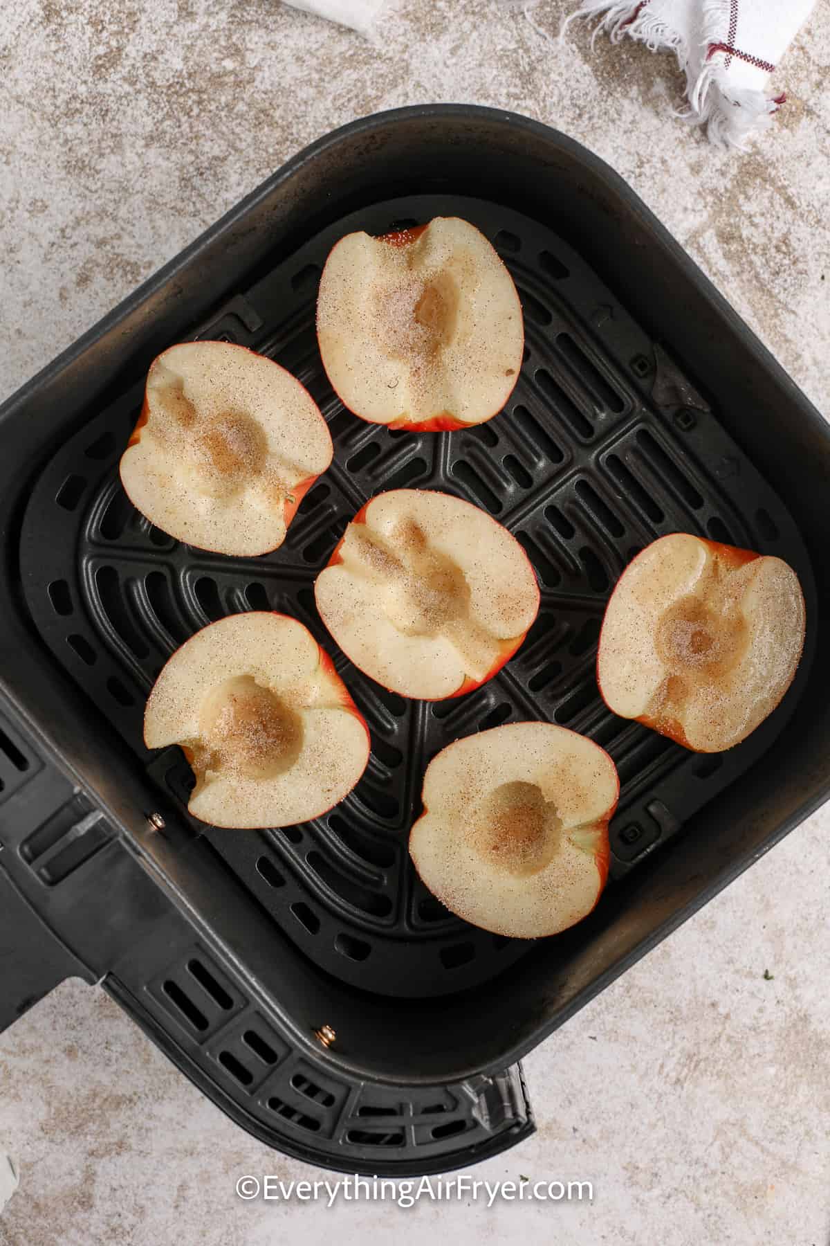 halved apples topped with cinnamon and sugar