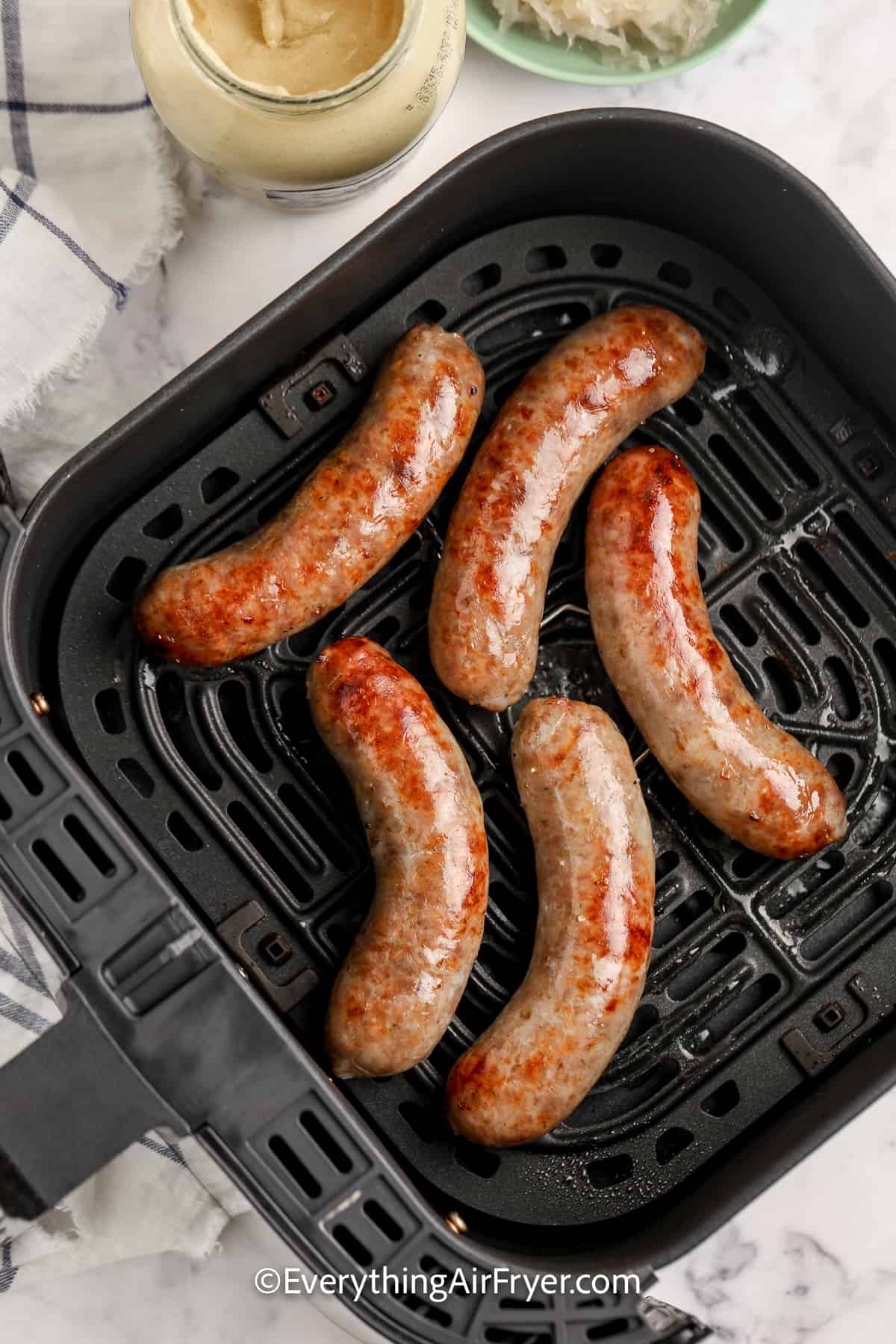 cooked sausages in air fryer tray