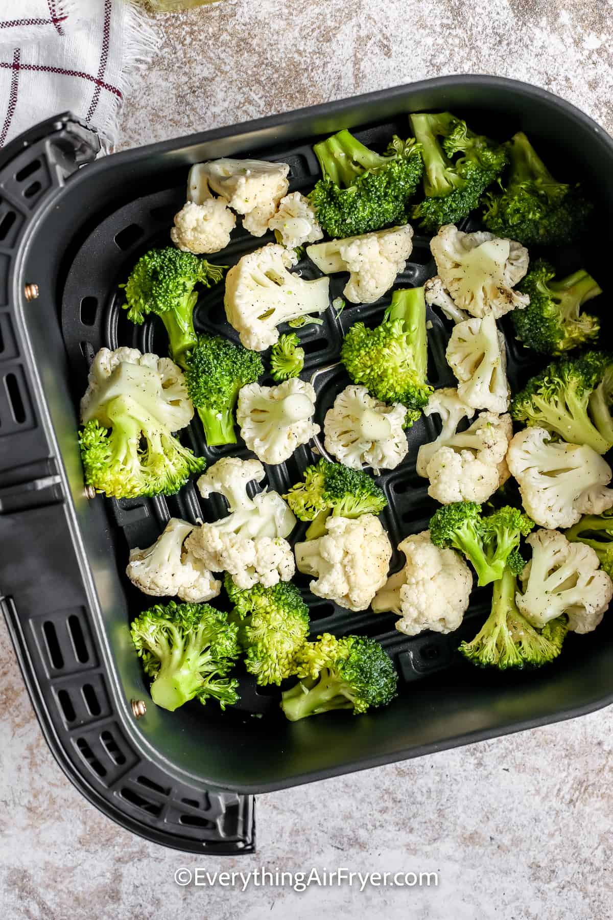 Seasoned Broccoli and Cauliflower in an air fryer basket