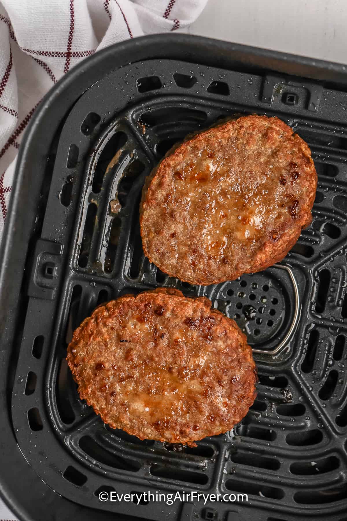 cooked burgers in an air fryer tray