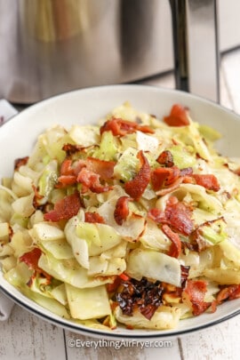 A serving dish with air fryer cabbage topped with bacon