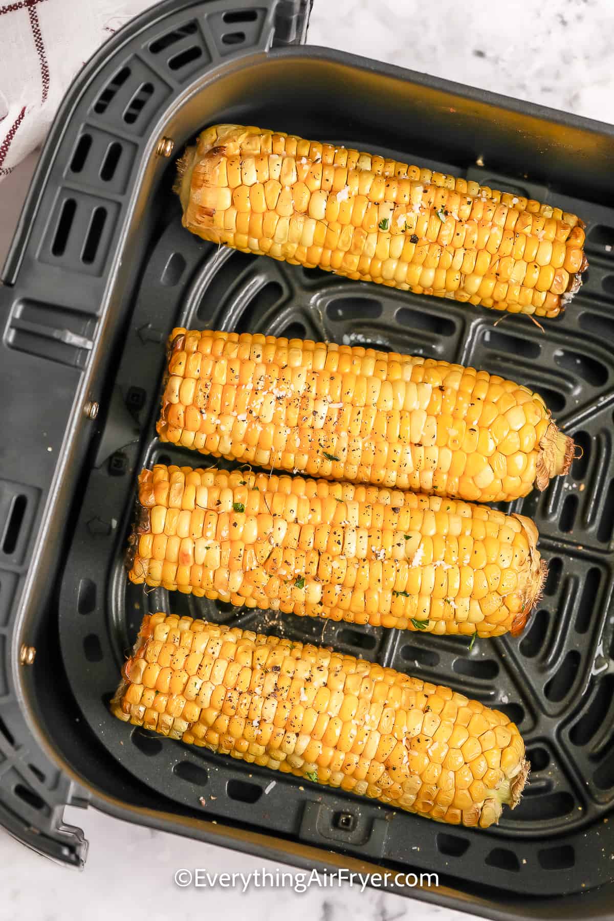 Cooked corn on the cob in an air fryer basket