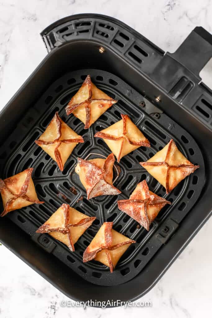 cooked wontons in an air fryer tray
