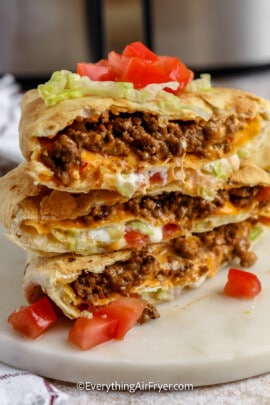 Three cross slices of air fryer crunchwrap supremes on a serving plate