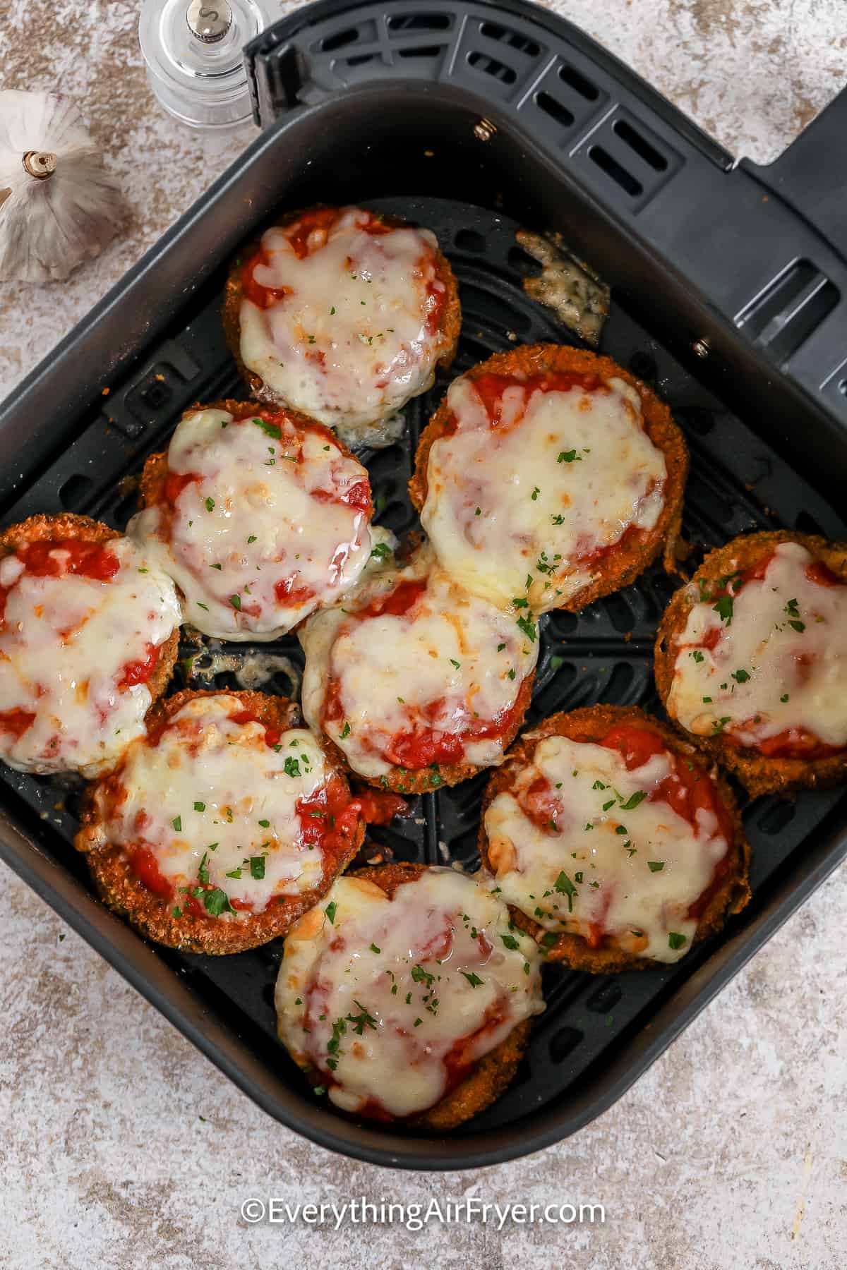 Cooked Eggplant Parmesan in an air fryer basket