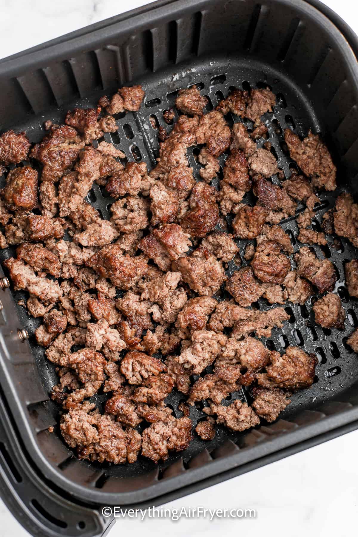 cooked ground beef in an air fryer tray
