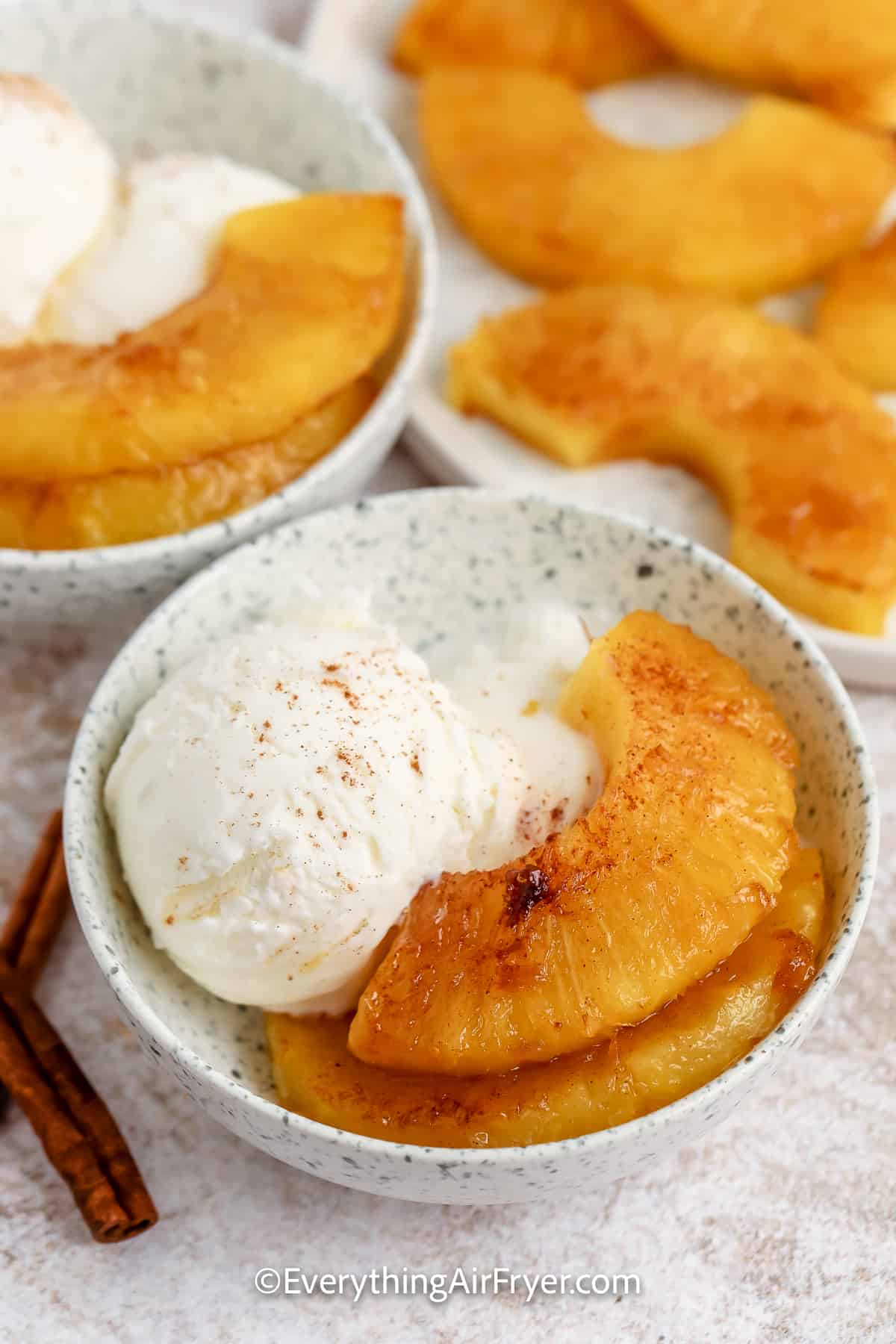 air fryer pineapple in a bowl with ice cream