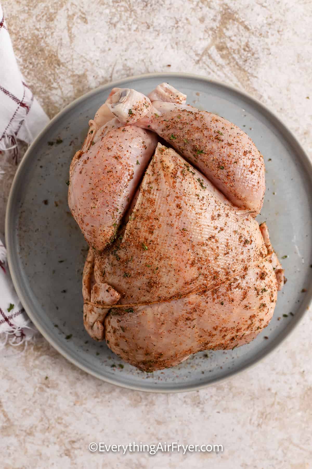 uncooked whole chicken with seasoning