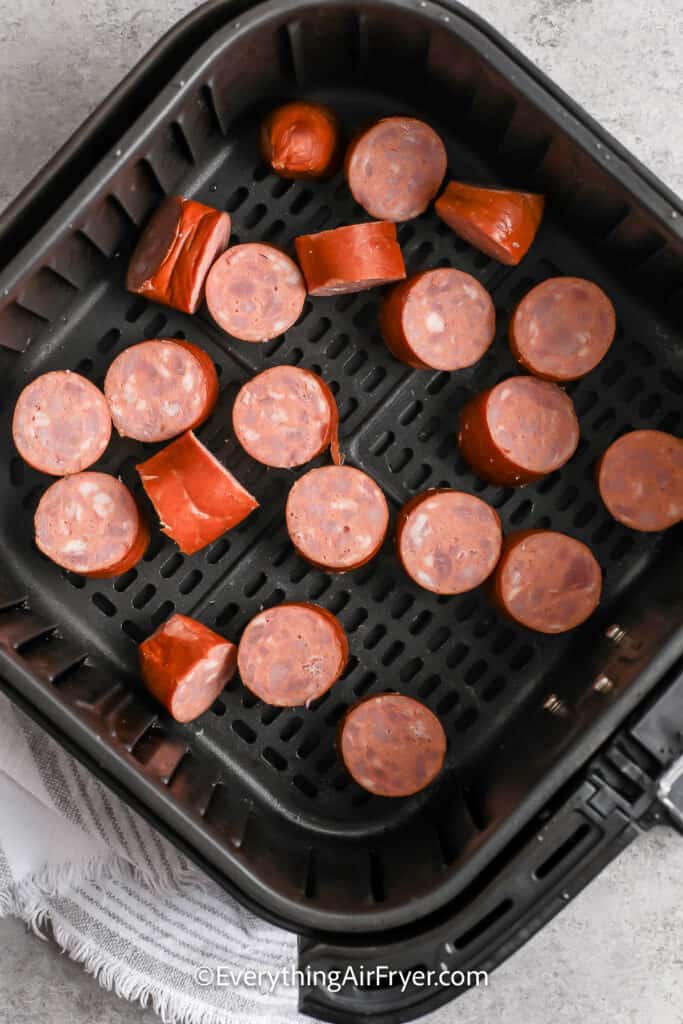 Smoked Sausage cut up in an air fryer basket