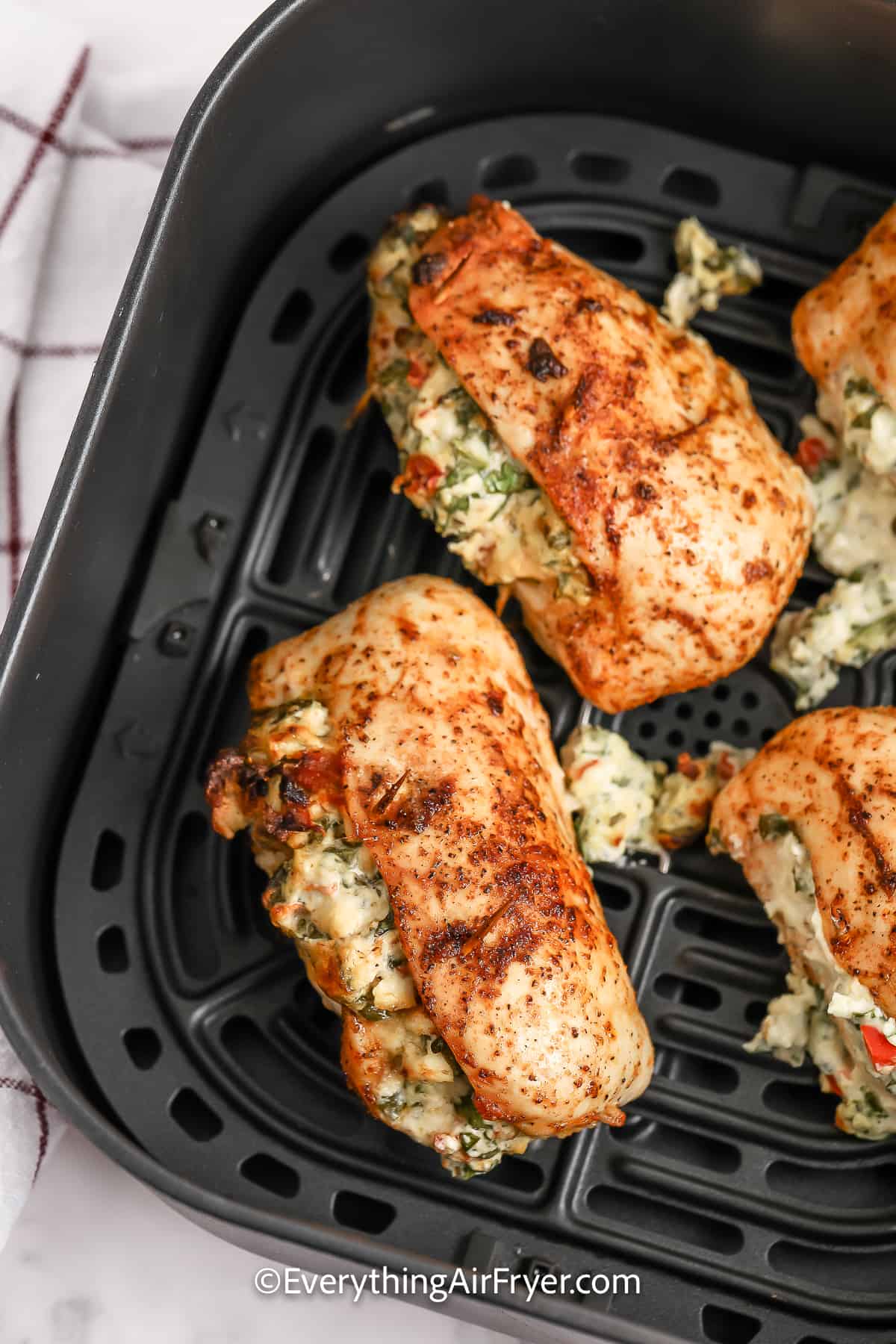 Cooked Stuffed Chicken Breasts in an air fryer basket