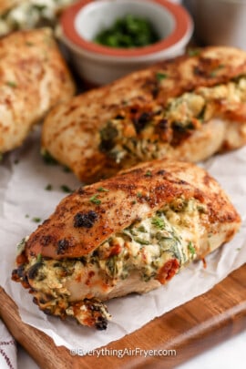 Air Fryer Stuffed Chicken Breasts on a cutting board garnished with parsley