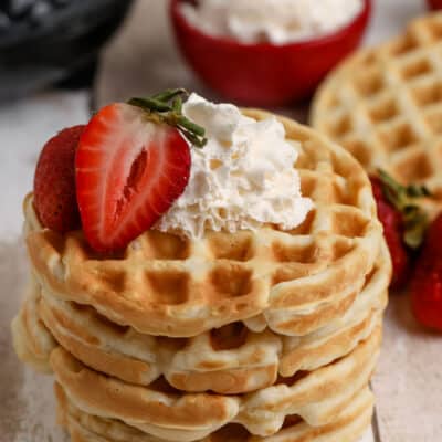 stack of eggo mini waffles with whipped cream and strawberries