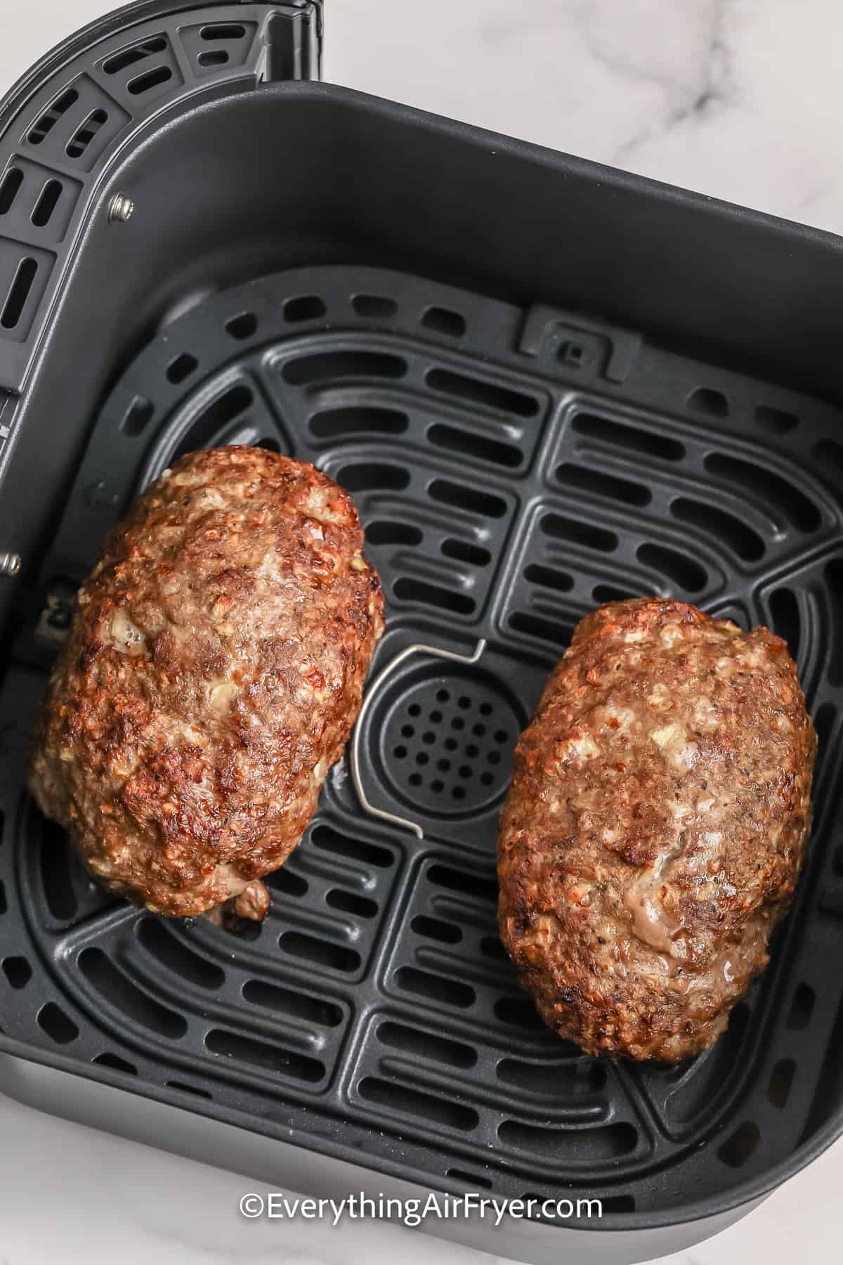 cooked meatloaf in an air fryer tray