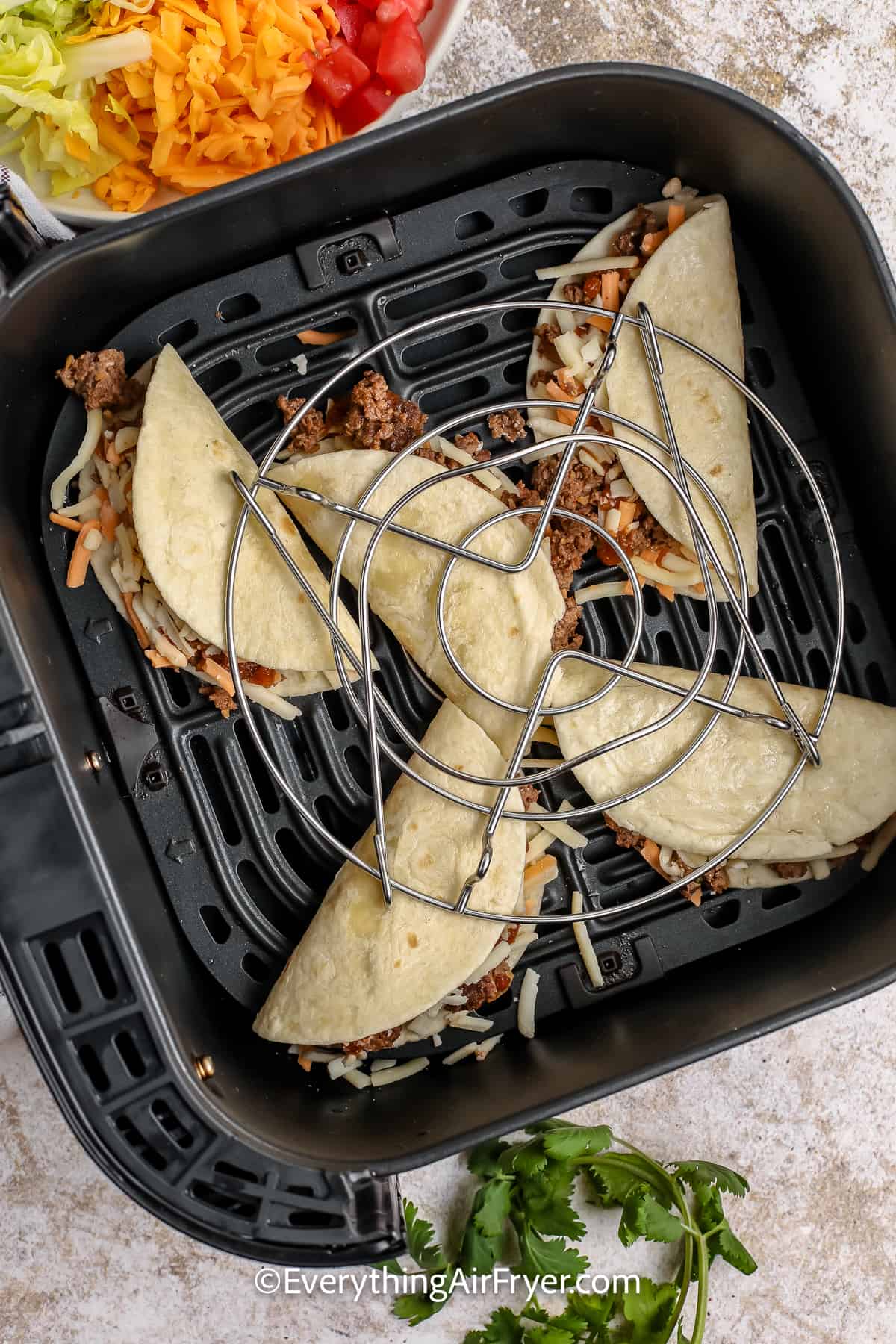 unbaked tacos in an air fryer tray