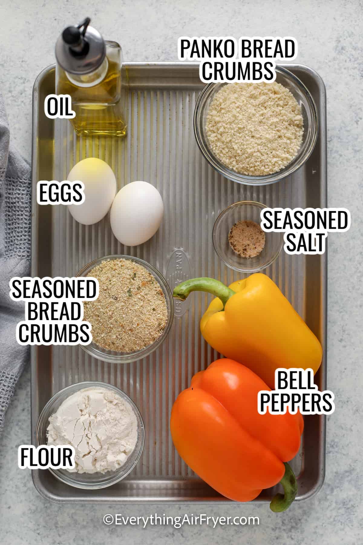 ingredients assembled to make crispy bell peppers including bell peppers, bread crumbs, eggs, flour, oil, and seasoned salt