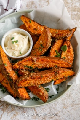 A bowl of Air Fryer Parmesan Sweet Potato Wedges with dip