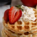stack of mini waffles topped with whipped cream and strawberries with text