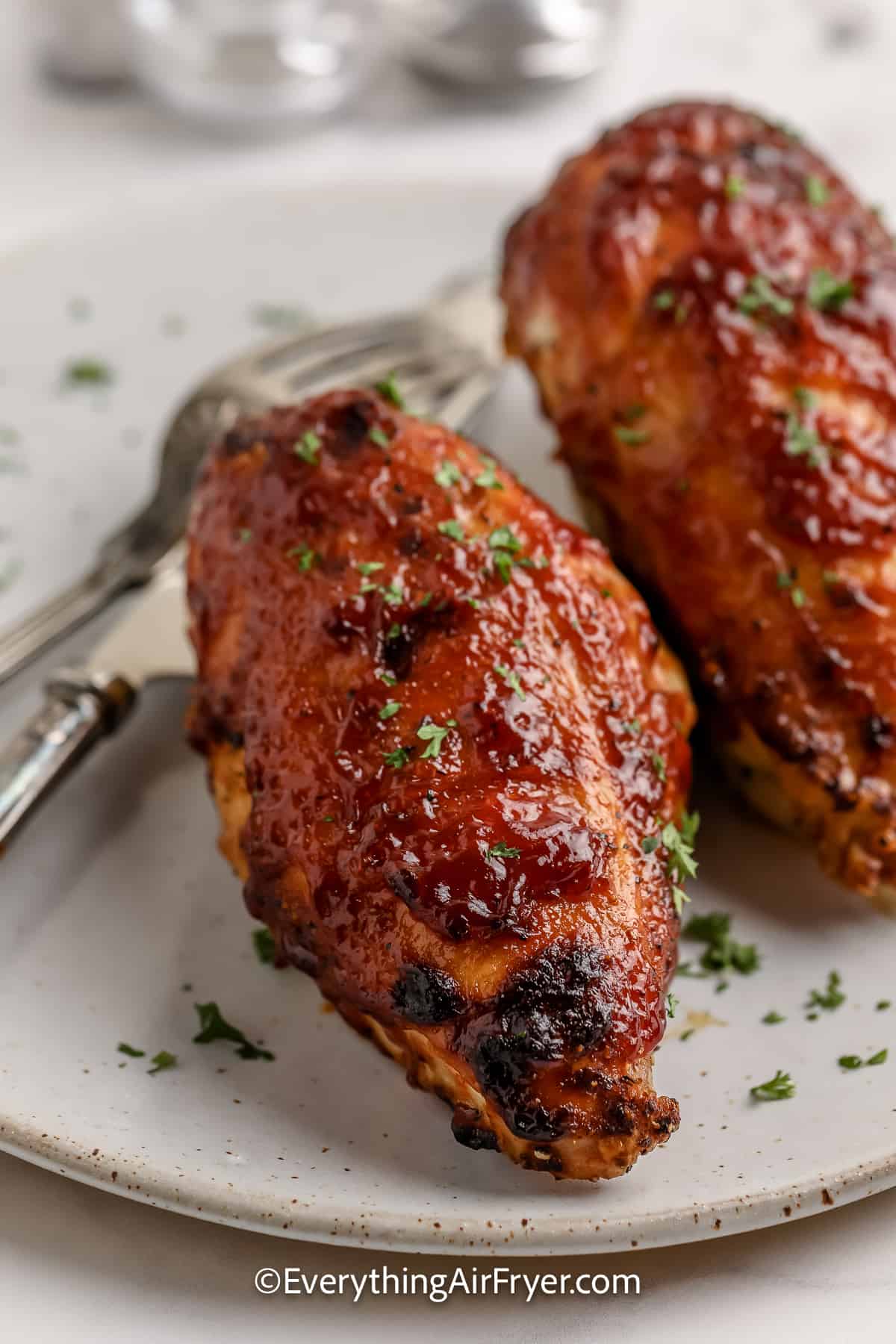 Air Fryer BBQ Split Chicken Breasts on a plate topped with parsley