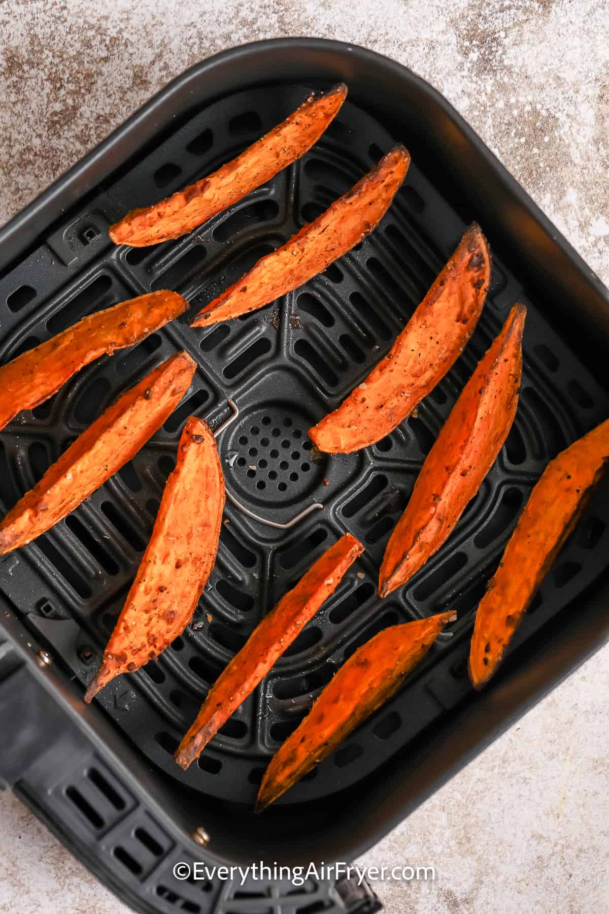 cooked sweet potato wedges in an air fryer tray