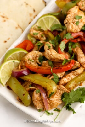 Air Fryer Chicken Fajitas ingredients plated with lime wedges