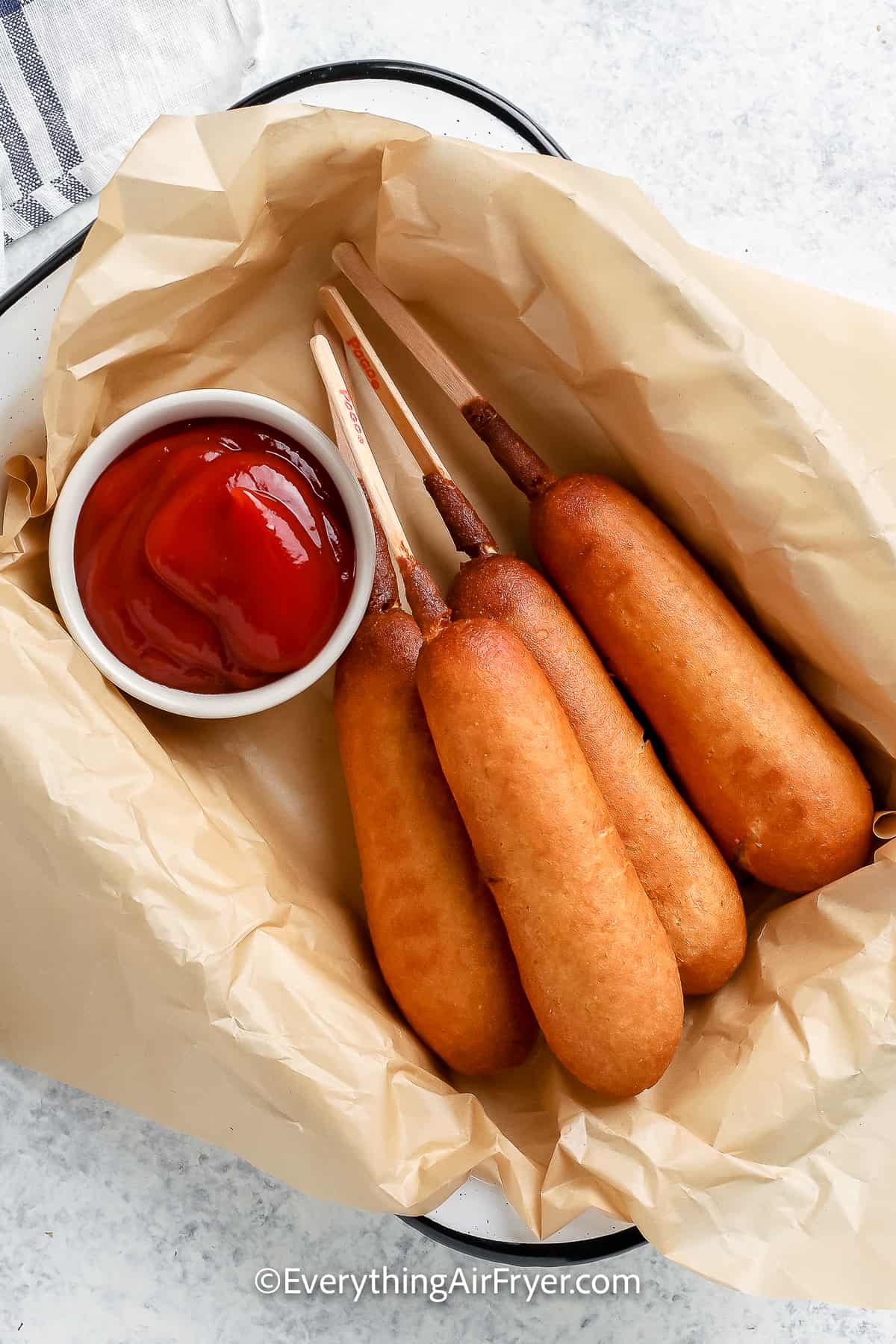 Air Fryer corn dogs in a serving dish with ketchup