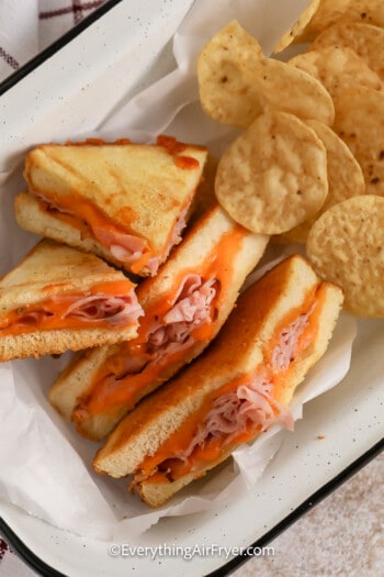 Air Fryer Grilled Ham and Cheese sandwich sliced into 4 pieces served with chips