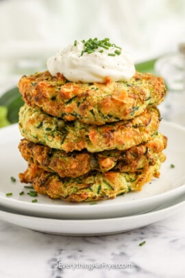 air fryer zucchini fritters stacked on a plate
