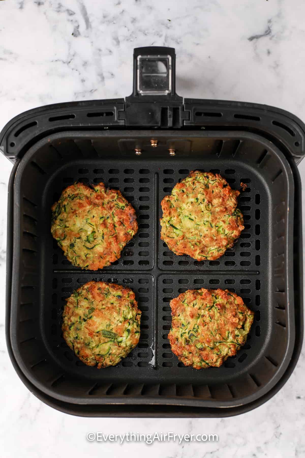 cooked air fryer zucchini fritters in an air fryer tray