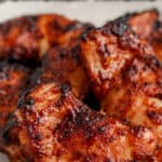 bbq boneless chicken thighs on a plate with text