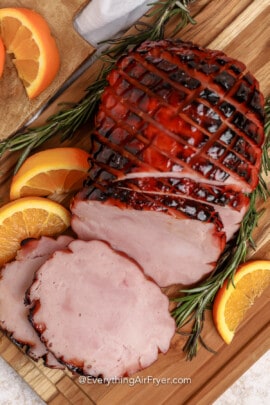 sliced Air Fryer Ham on a board with garnish