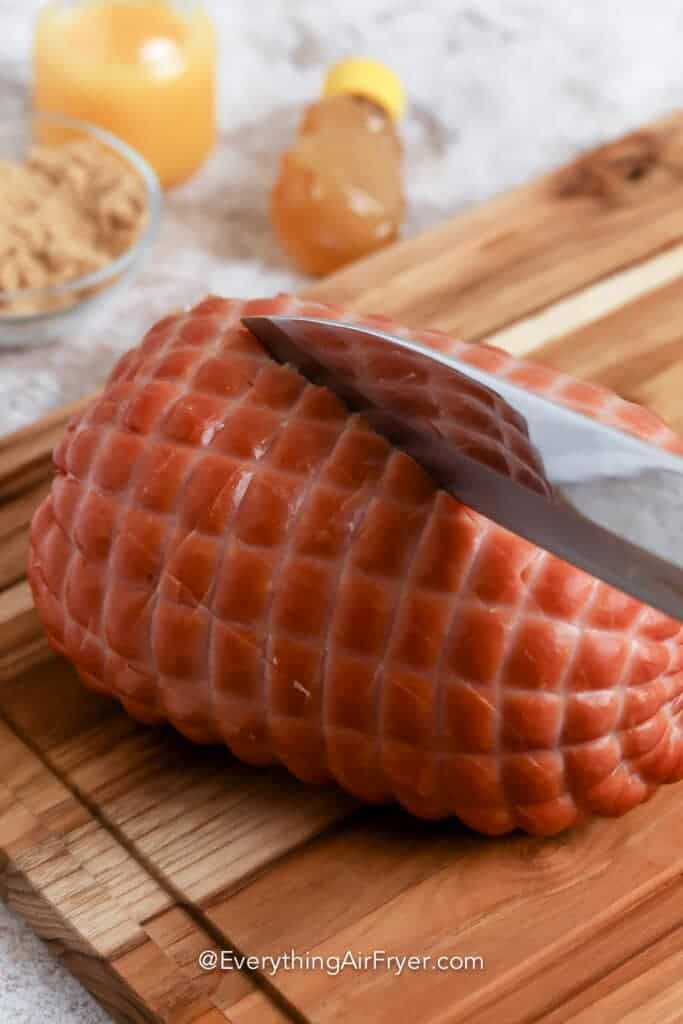 Air Fryer Ham being sliced on a wooden board