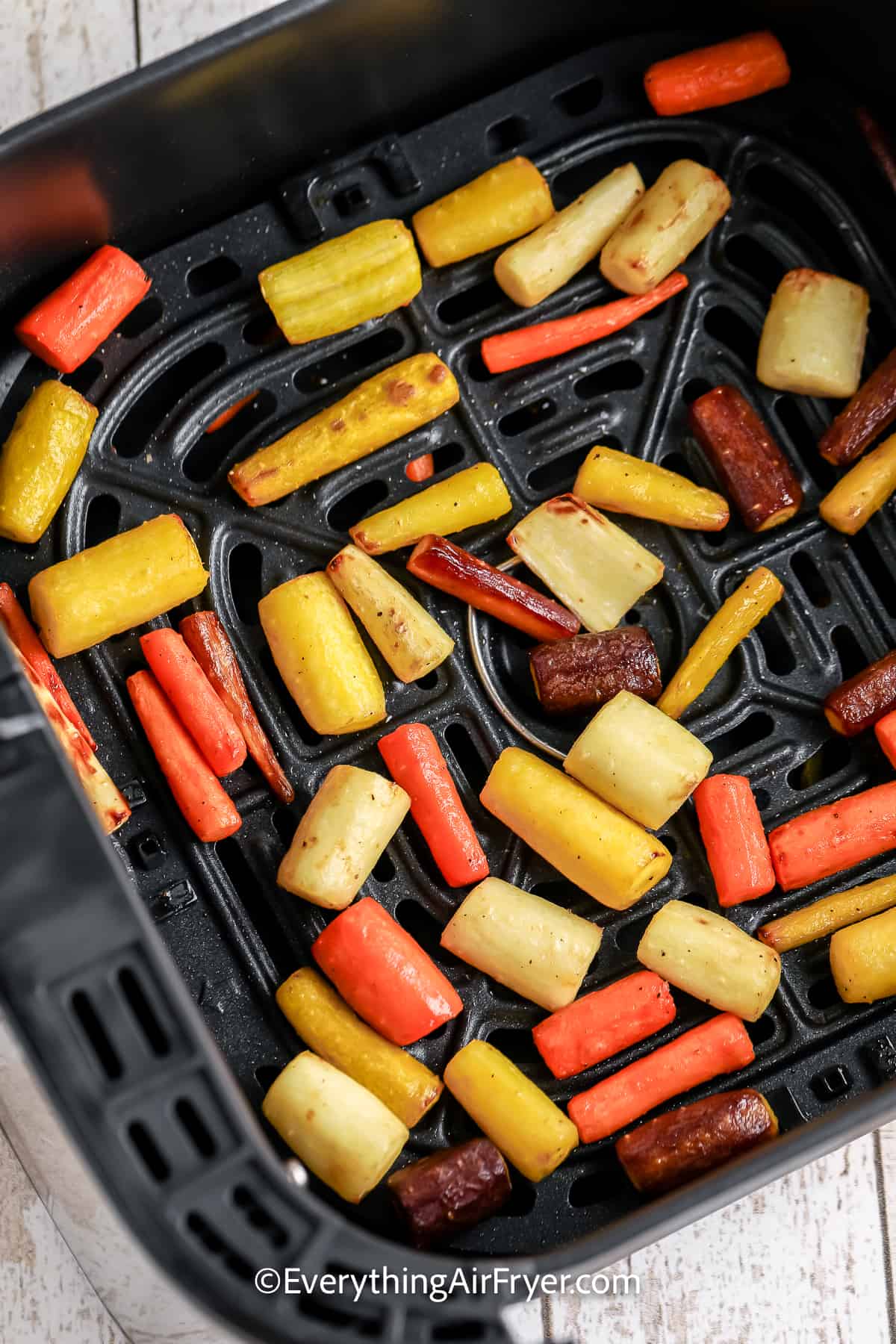 cooked rainbow carrots in an air fryer tray