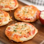cooked mini pizzas on a cutting board